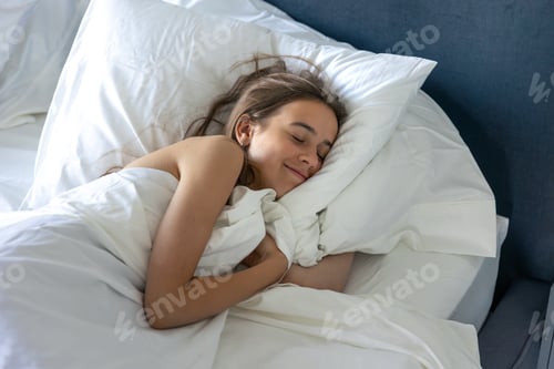 Preview: Girl sleeping while hugging duvet top view. Quiet sleep.