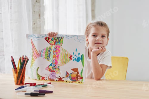 Preview: Nice daylight. Cute little girl in art school shows her first paintings drawn by pencils and markers