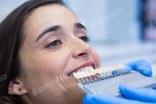 Preview: Close up of dentist holding equipment while examining woman at clinic