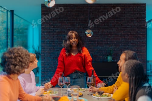 Preview: Woman making a toast during a friendsgiving celebration dinner