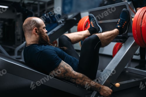 Preview: Strong athlete on exercise machine with barbell