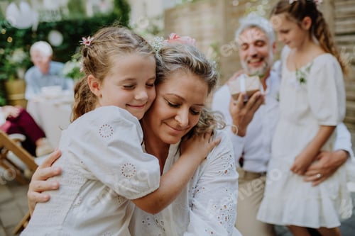 Preview: Mature bride and groom receiving congratulations from their little daughters at wedding reception