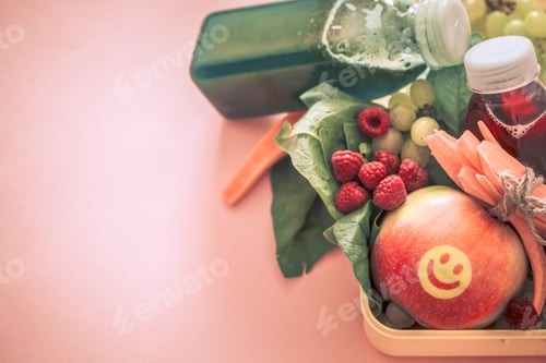 Preview: Breakfast or lunch with healthy food in a yellow box, on a pink background.