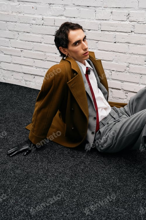 Preview: Stylish man poses elegantly in a modern setting with a unique fashion statement