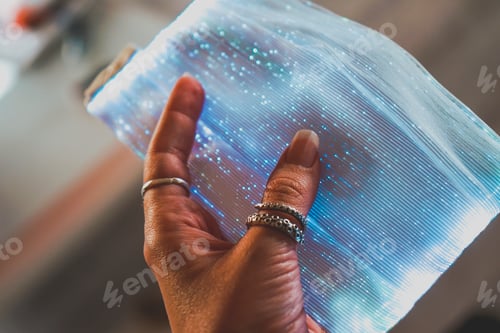 Preview: Hand holding a new and futuristic face mask with colorful led lights