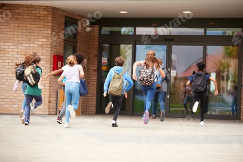Preview: Group Of High School Students Running Into School Building At Beginning Of Class