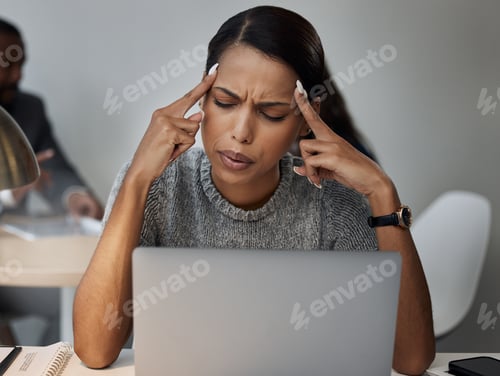 Preview: Shot of a young businesswoman experiencing a headache while at work