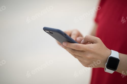 Preview: Hands using smartphone outdoors