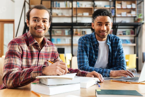 Preview: Young happy african men students sitting in library