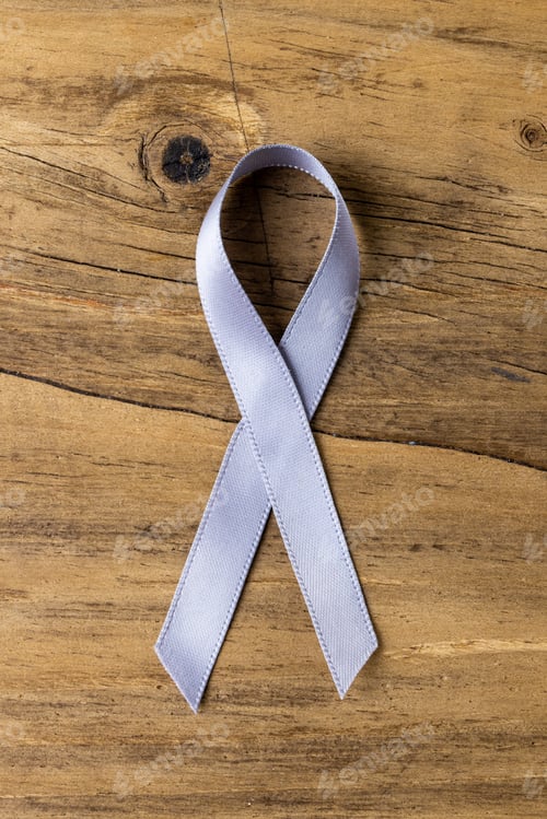 Preview: Overhead clos-up of blue stomach cancer awareness ribbon on wooden table, copy space