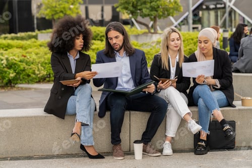 Preview: Business Colleagues Reviewing Documents Outside Office Building