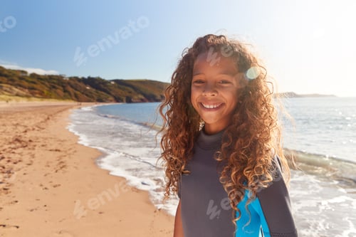 Preview: Portrait Of Young Girl Wearing Wetsuit Standing By Waves On Summer Beach Vacation