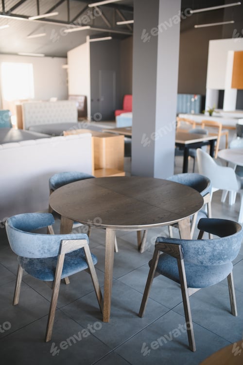 Preview: Round dining table and blue chairs in furniture store
