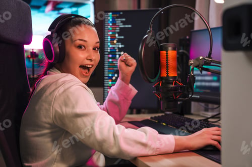 Preview: Happy young woman streamer gamer in headphones