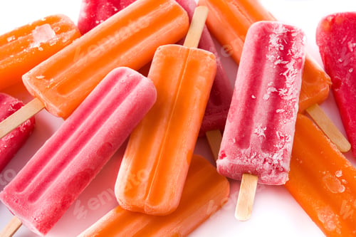 Preview: Orange and strawberry popsicles on ice cubes.