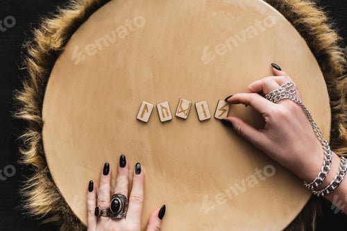 Preview: Top View of Woman Touching Ancient Runes on Wooden Surface
