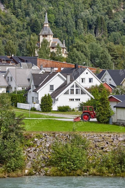 Preview: Norwegian traditional village, river and hill. Norway rural landscape. Vertical