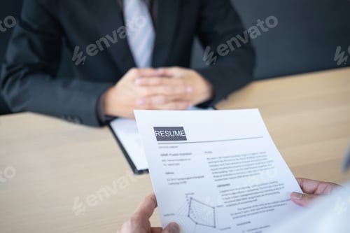 Preview: Employer or recruiter holding reading a resume during about colloquy his profile of candidate