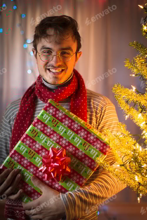 Preview: Portrait of young man holding christmas gift