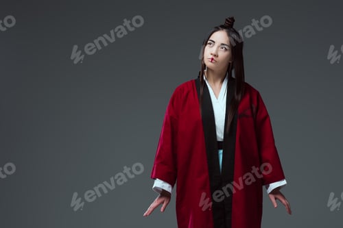 Preview: beautiful young asian woman in kimono looking away isolated on grey
