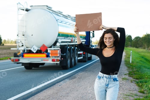 Preview: Hitchhiker on the road is holding a blank cardboard sign