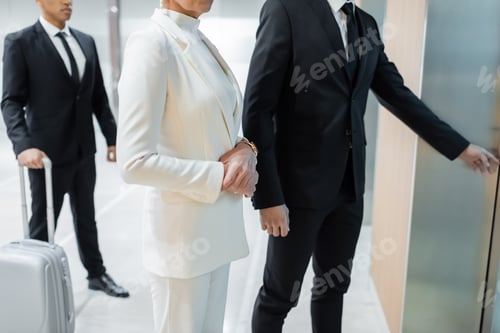 Preview: cropped view of interracial bodyguards escorting mature businesswoman in hotel during business trip