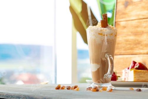 Preview: Glass of latte coffee and piece of strawberry cheesecake on gray table