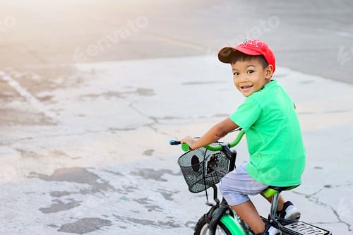 Preview: Soft focus, Kid and sport concept. Happy asian child boy riding a bike on the road.