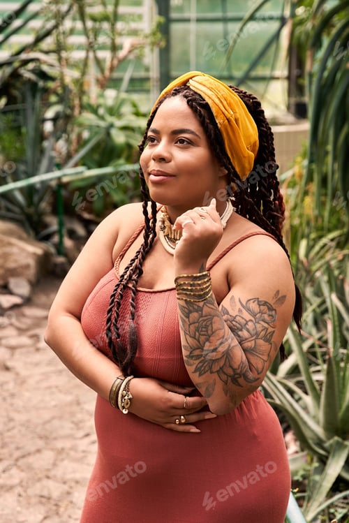 Preview: Joyful African American woman radiates in a vibrant greenhouse of lush plants