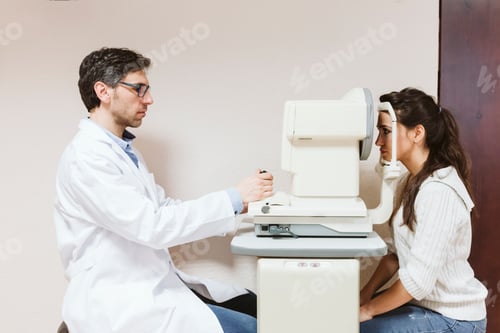 Preview: Ophthalmologist man examining young woman eyes in clinic.