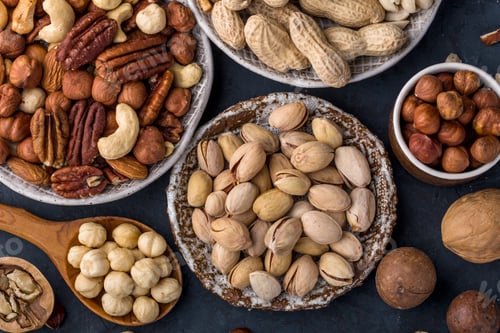 Preview: Variety of nuts in plates on a blue background top view