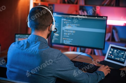 Preview: Professional programmer is working indoors. Neon lighting