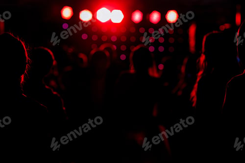 Preview: cheering crowd in front of bright red stage lights. Silhouette image of people dance in disco