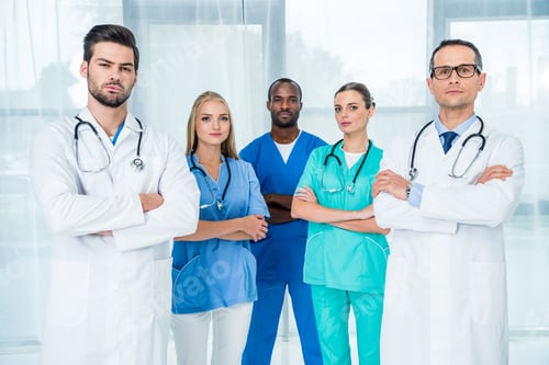 Preview: multiethnic team of doctors with crossed arms looking at camera