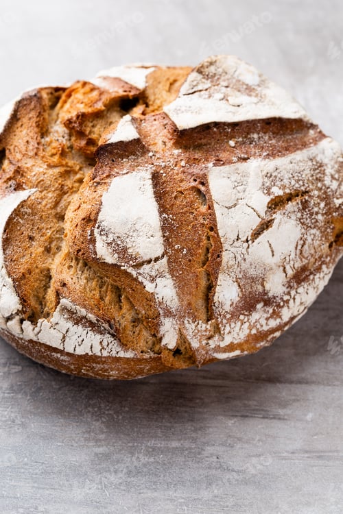 Preview: Freshly baked bread on dark gray kitchen table, top view.