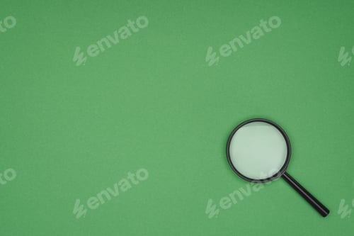 Preview: Top view of magnifying glass on green background