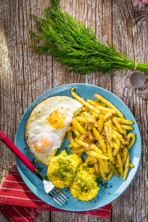 Preview: Fried egg served with boiled potatoes and yellow beans.