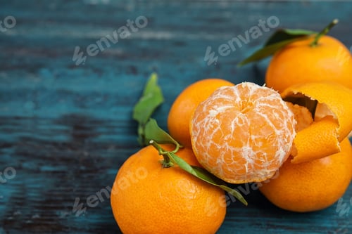Preview: Fresh ripe tangerines with green leaves on table. Space for text