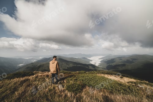 Preview: The man standing on a top of a mountain
