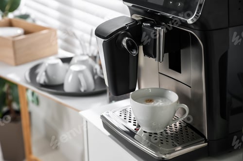 Preview: Modern coffee machine with cup of cappuccino in office. Space for text