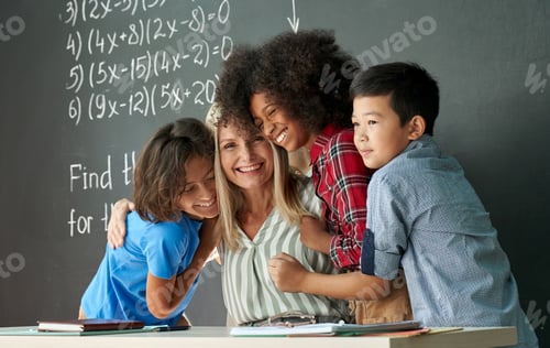 Preview: Happy diverse kids school children students hugging female teacher in classroom.