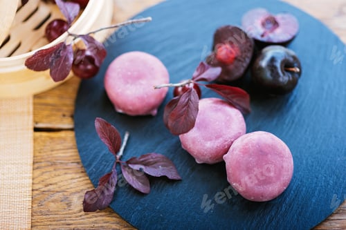 Preview: Purple plums on black plate, wooden table food fruit plant. Mochi asian dessert