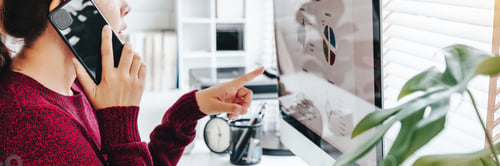 Preview: Asian woman working from home using computer and drinking coffee in her bedroom