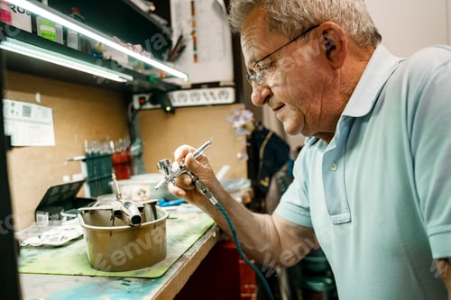 Preview: Portrait of senior man painting model airplane in workshop at home. Concept of craft, handmade