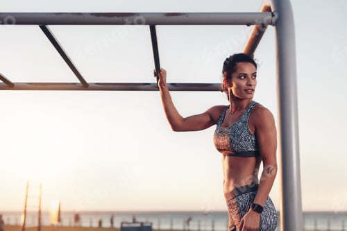 Preview: Muscular woman standing by monkey bars