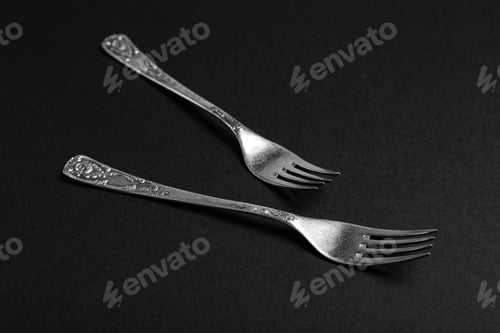 Preview: Vintage silver forks on black background, closeup
