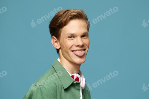 Preview: Smiling Young American Man Poses Casually Against Blue Studio Wall
