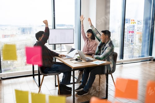 Preview: Cheerful team of architects celebrating success in office meeting