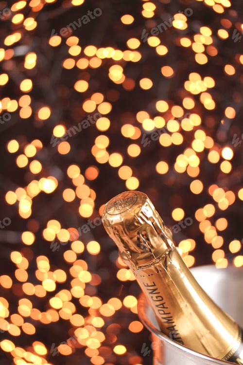 Preview: Champagne bottle against sparkling golden bokeh background.