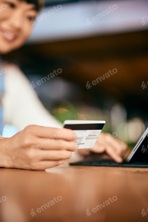 Aperçu: Close-up of the female holding a credit card, buying something online, and entering data.
